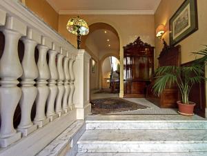 a hallway with white columns and a staircase with a potted plant at Hotel Silva in Rome