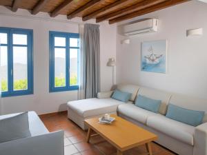 a living room with a couch and a table at Bella Resorts Andros in Andros