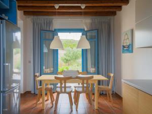 a kitchen with a table and chairs and a window at Bella Resorts Andros in Andros