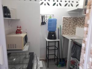 una pequeña cocina con fregadero y microondas en Ap 04-A 50 Metros da Praia Flats Completamente Mobiliados, en Paulista