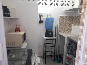 a small kitchen with a sink and a microwave at Ap 04-A 50 Metros da Praia Flats Mobiliados para 2 Pessoas in Paulista +6 photos