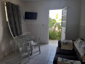 a living room with a table and chairs and a couch at Ap 04-A 50 Metros da Praia Flats Mobiliados para 2 Pessoas in Paulista