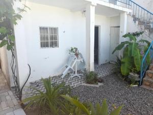 a white house with a white staircase in a courtyard at Ap 04-A 50 Metros da Praia Flats Mobiliados para 2 Pessoas in Paulista