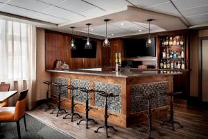 a bar in a restaurant with a table and chairs at Four Points by Sheraton Barrie in Barrie