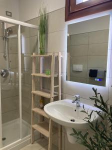 a bathroom with a sink and a shower and a mirror at Outdooredo Garda Torbole in Nago-Torbole