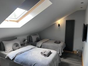 um quarto no sótão com 2 camas e uma janela em Entire Two Bedroom Guest Home Free Parking em Nottingham