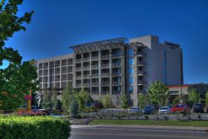 Courtyard by Marriott Pigeon Forge في بيدجن فورج: مبنى كبير فيه سيارات تقف امامه