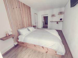 - une chambre avec un grand lit blanc et du parquet dans l'établissement Santi e Benny Apartment, à Ponta Delgada