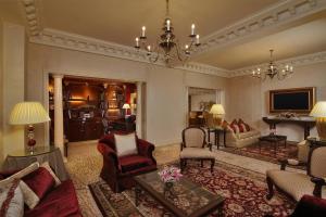 ITC Windsor, a Luxury Collection Hotel, Bengaluru في بانغالور: غرفة معيشة مليئة بالاثاث والثريا