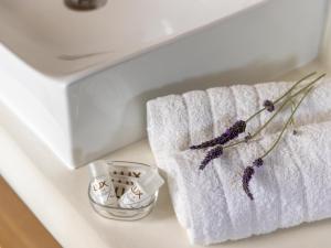 a towel and a bowl of lavender next to a sink at Bella Resorts Andros in Andros