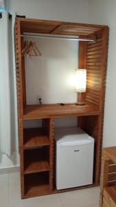 a wooden book shelf with a computer in a room at Pousada Flôr do Atlântico in Fernando de Noronha