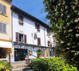 a white building with a store on a street at Appartamenti Adriana Sirmione in Sirmione