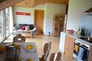 een keuken en een woonkamer met een bank en een tafel bij Apartment Magdalena in Bezau