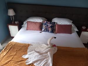 a bed with a swan sitting on top of it at Casa das Cales in Angra do Heroísmo