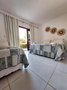 a bedroom with two beds and a mirror on the wall at Pousada Recanto dos Milagres in São Miguel dos Milagres