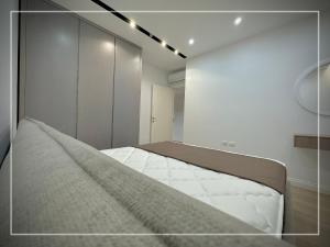 a bedroom with a large bed and a white wall at Luxury Apartment - San Pietro in Durrës