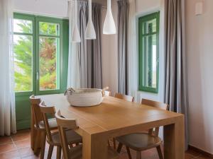 a dining room with a wooden table and chairs at Bella Resorts Andros in Andros