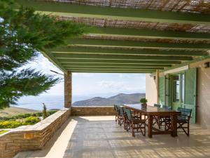 a patio with a table and chairs on a house at Bella Resorts Andros in Andros
