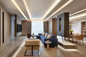 a living room with a blue couch and a table at Sheraton Istanbul City Center in Istanbul