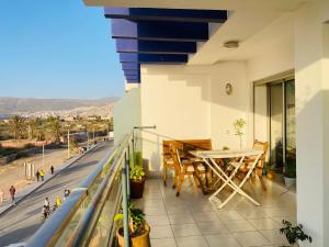 a balcony with a table and a view of a street at Beach and Mountain View Surf Apartment in Aourir