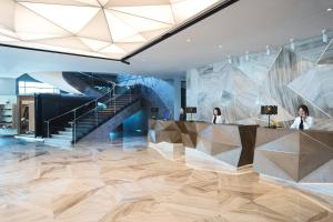 a lobby with a reception desk and a staircase at Renaissance Riverside Hotel Saigon in Ho Chi Minh City