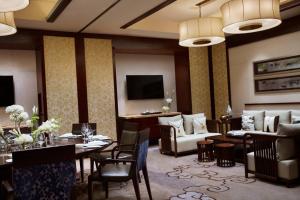 a hotel room with a dining table and a living room at Renaissance Wuhan Hotel in Wuhan