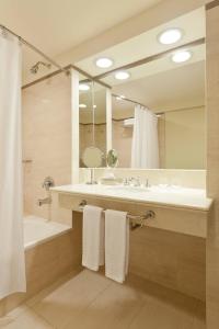 a bathroom with a sink and a tub and a mirror at Sheraton Salta Hotel in Salta