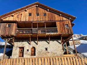 a large wooden house with a balcony on top at DOLOMITISCAPE CHALET in Badia
