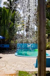 a swimming pool in a yard with palm trees at Pousada Recanto dos Milagres in São Miguel dos Milagres