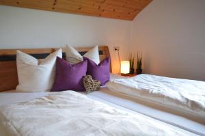 1 Schlafzimmer mit 2 Betten mit lila und weißen Kissen in der Unterkunft Apartment Magdalena in Bezau