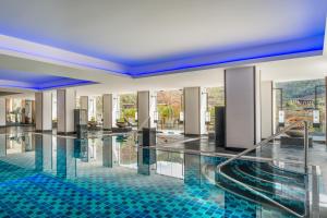 a swimming pool with blue tiles in a building at Le Meridien Paro Riverfront in Paro