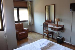 Schlafzimmer mit einem Bett, einem Schreibtisch und einem Stuhl in der Unterkunft São Roque Hotel & Suites in Bragança