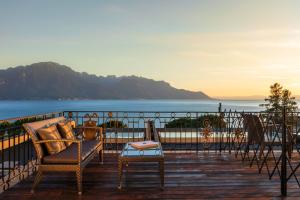 a balcony with chairs and a view of the ocean at Grand Hotel Suisse Majestic, Autograph Collection in Montreux