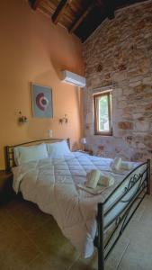 a large bed in a room with a stone wall at Stone Made Private Pool Villas Kriopigi in Kriopigi