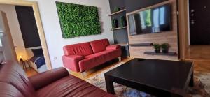 - un salon avec un canapé rouge et une télévision dans l'établissement Apartman Wolf, à Varaždin