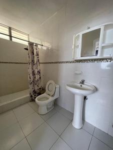 a bathroom with a toilet and a sink at Departamento hermoso frente a chipipe in Salinas