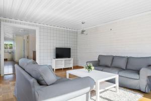 a living room with two couches and a tv at Scenic Seaside Retreat near Northvolt Ett in Skellefteå