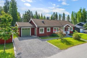 une maison avec une maison rouge et une allée dans l'établissement Scenic Seaside Retreat near Northvolt Ett, à Skellefteå