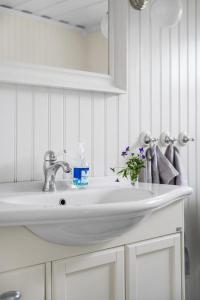 a bathroom sink with a bottle of soap on it at Scenic Seaside Retreat near Northvolt Ett in Skellefteå