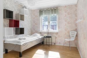 a bedroom with a bed and a window and a chair at Scenic Seaside Retreat near Northvolt Ett in Skellefteå