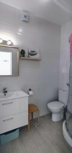 a white bathroom with a toilet and a sink at Estudio Patio San Paulino in Barbate