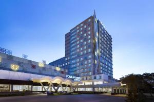 a tall building with a sign in front of it at Four Points by Sheraton Makassar in Makassar