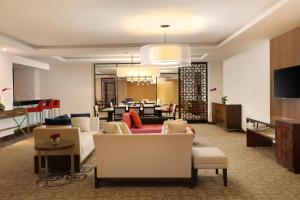 a living room with couches and a dining room at Four Points by Sheraton Makassar in Makassar