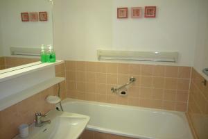 ein Badezimmer mit einer Badewanne und einem Waschbecken in der Unterkunft Frische Brise 01.09 in Cuxhaven