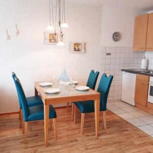 クックスハーフェンにあるFrische-Brise-01-09のキッチン(木製テーブル、青い椅子付)