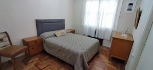 1 dormitorio pequeño con 1 cama y 1 silla en Depto. Corrientes, zona centro Mardel en Mar del Plata