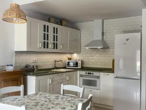 a kitchen with white appliances and a table with chairs at Apartamento en la Playa Benicarló Peñíscola in Benicarló