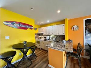 a kitchen with a table and a surfboard on the wall at Sandpiper Cove 8224 in Destin