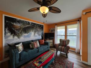 a living room with a blue couch and a fan at Sandpiper Cove 8224 in Destin