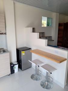 a kitchen with a counter and two stools at Hostal Mi Elvirula in Santa Marta